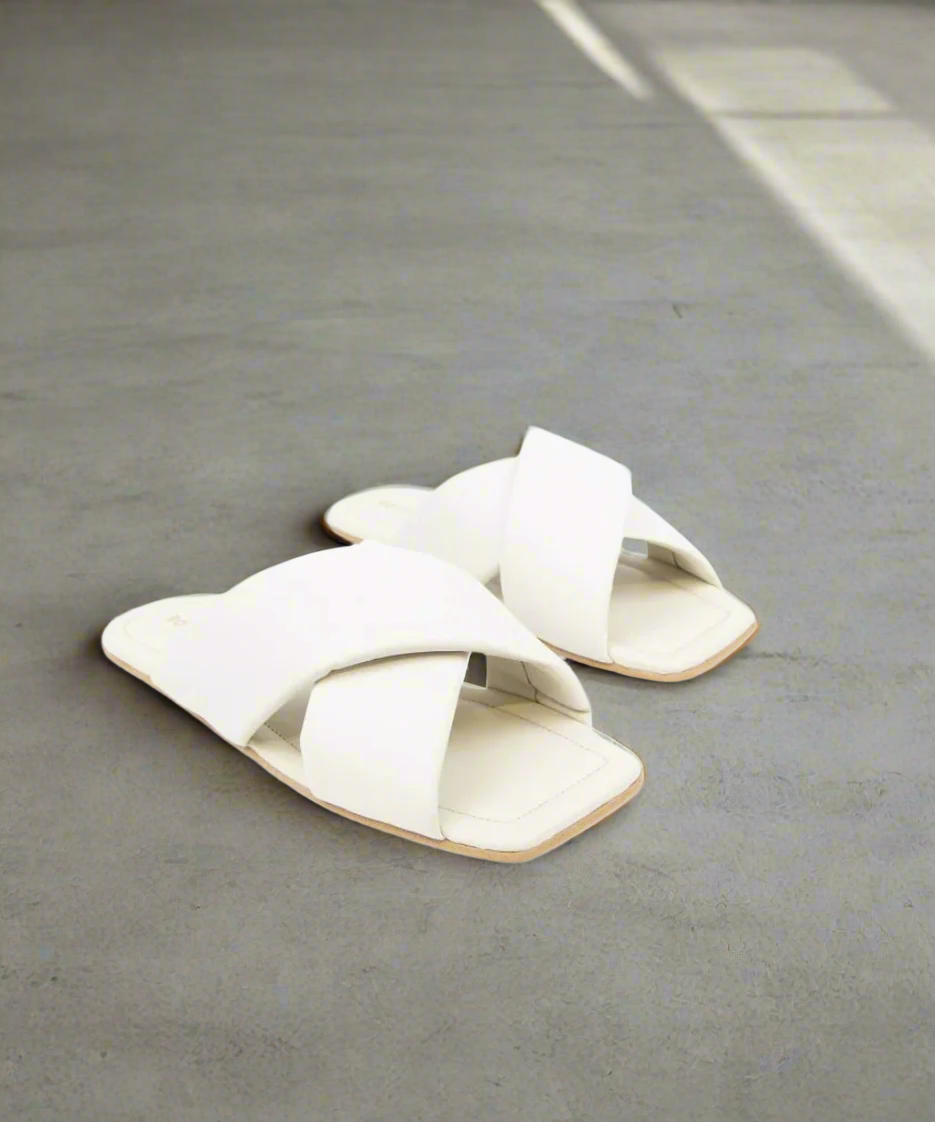 Pair of white sandals on a grey background