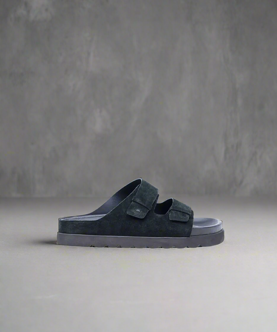 Black sandal with strap design on a gray background