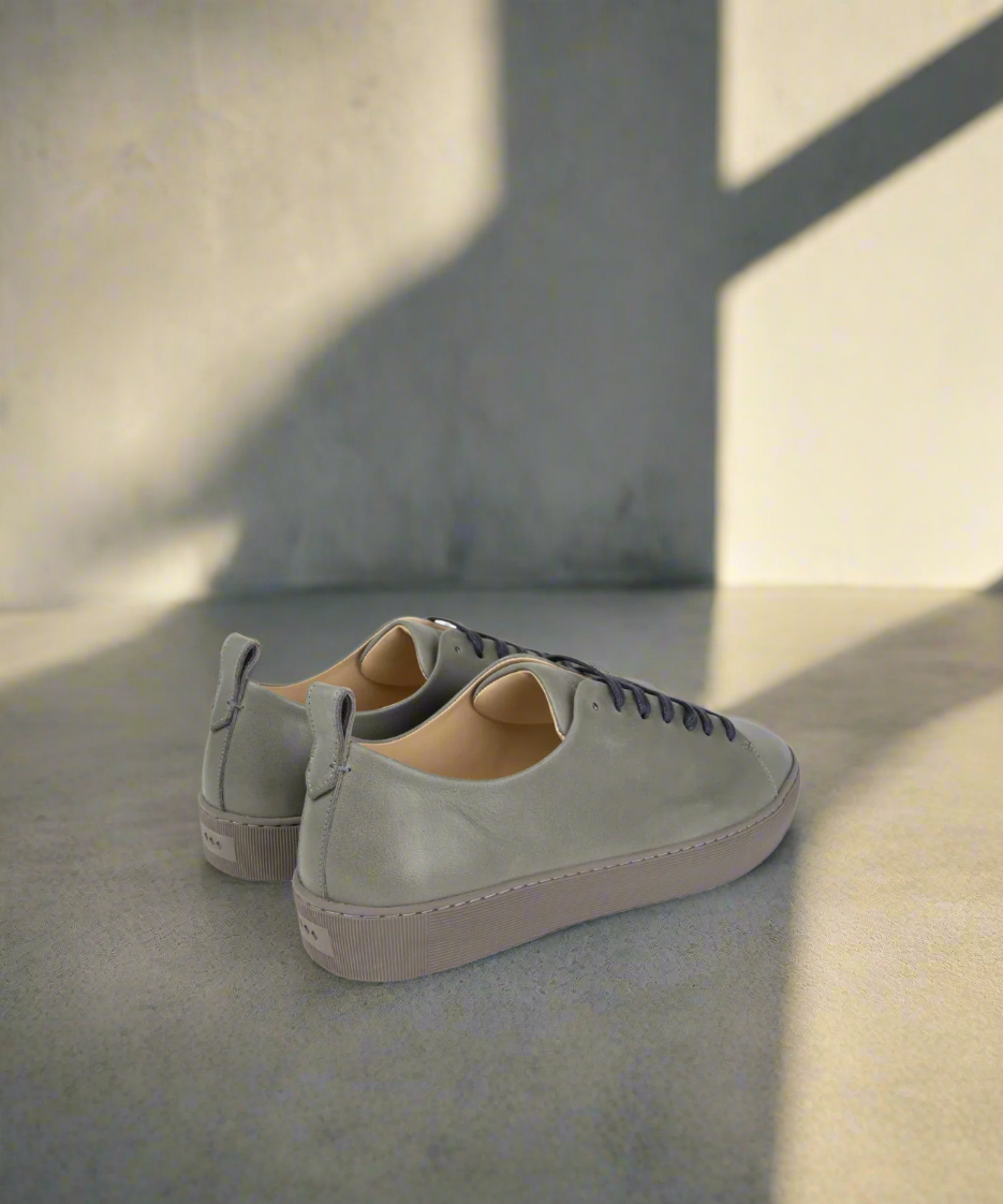 Pair of grey sneakers on a grey background