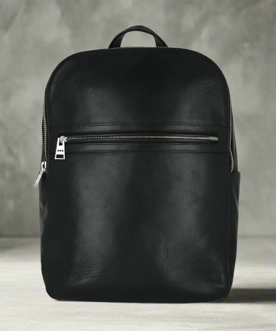 Black leather backpack on a gray background
