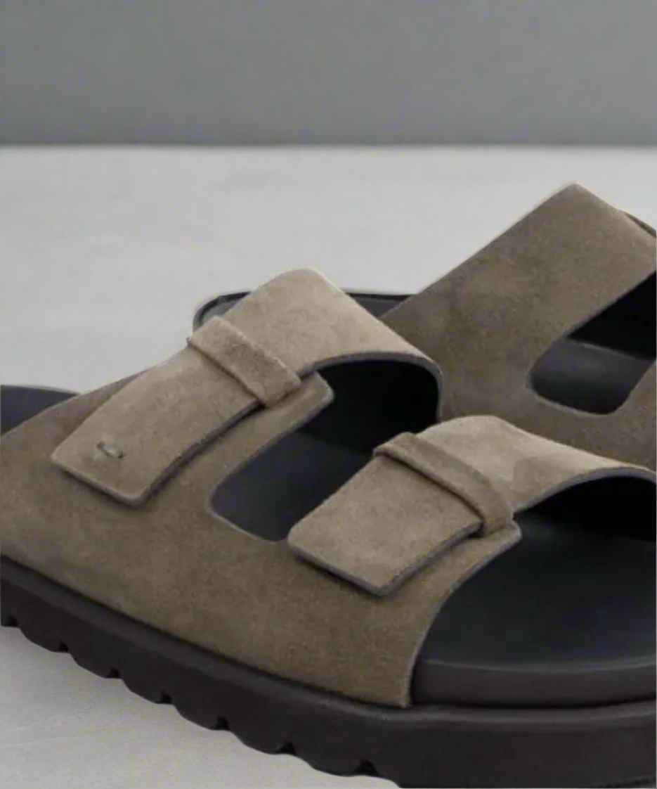 Brown sandals with velcro straps on a gray background