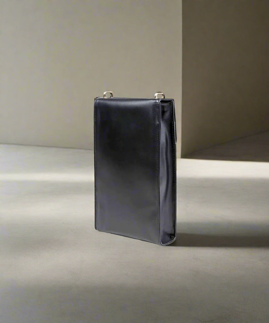 Black leather handbag on a gray background