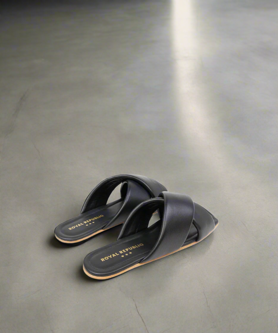 Black sandals with 'ROYAL' branding on a grey background