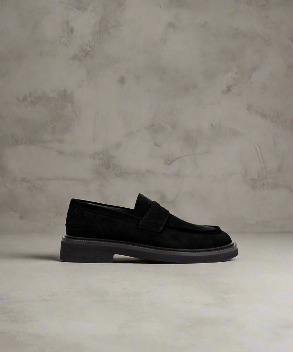 Black Royal RepubliQ loafer shoe on a textured gray background