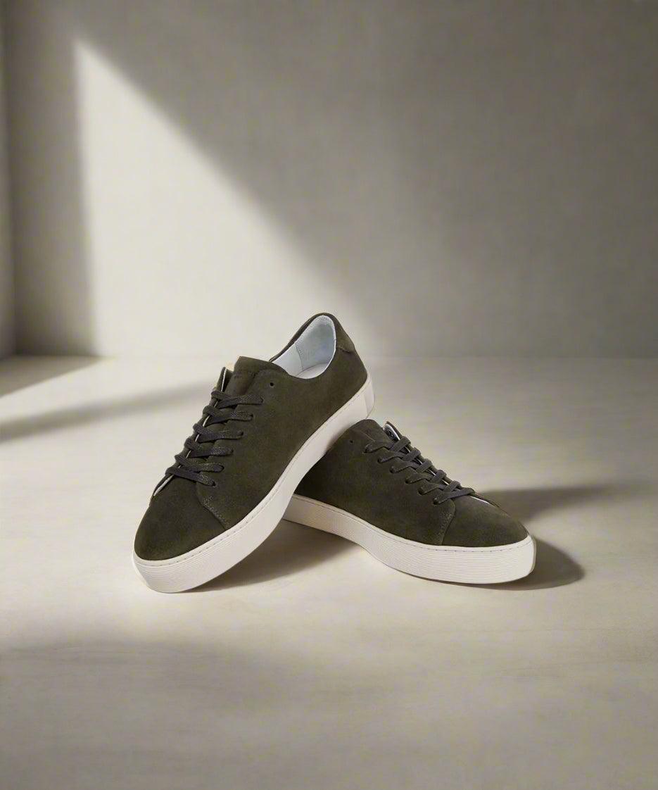 Pair of khaki sneakers on a gray background