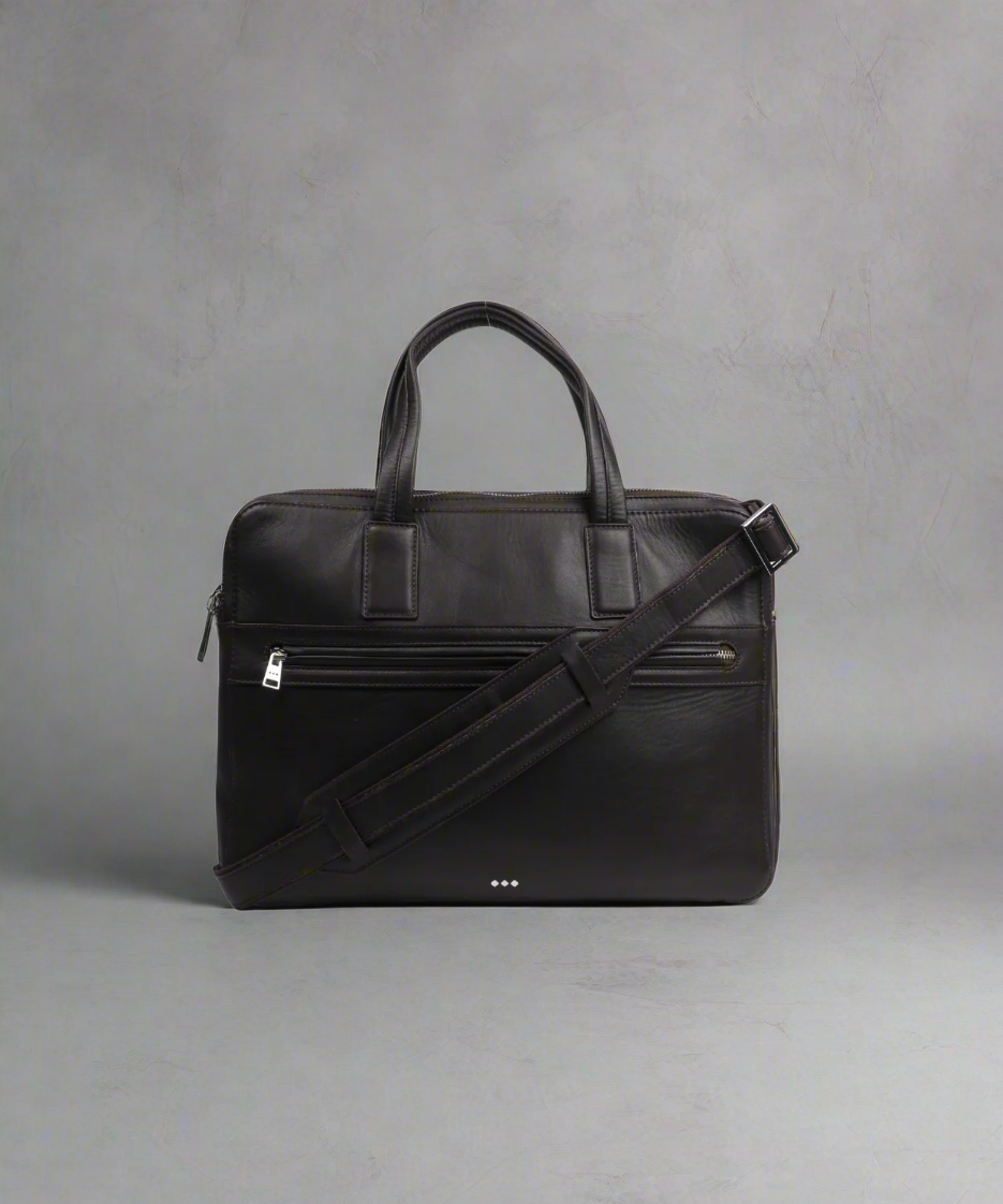 Black leather briefcase with a shoulder strap on a gray background