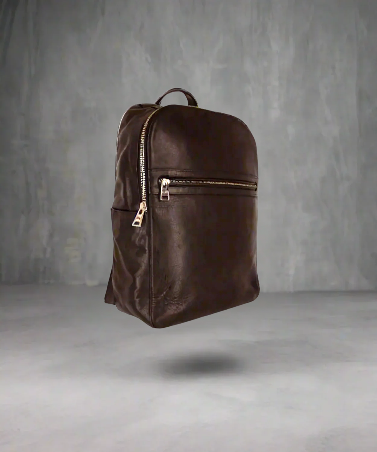 Brown Royal RepubliQ backpack with gold zippers on a gray background