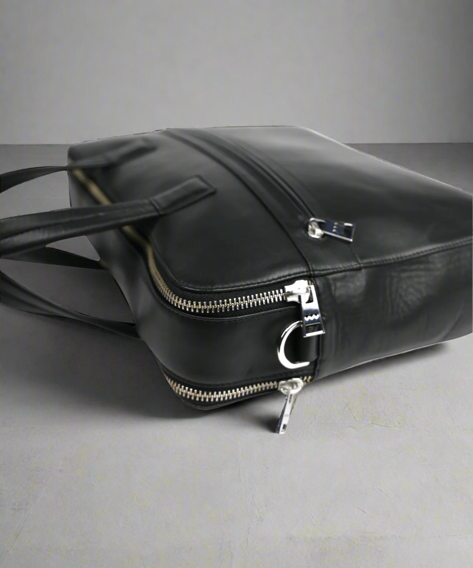 Black Royal RepubliQ leather bag with zippers on a gray background