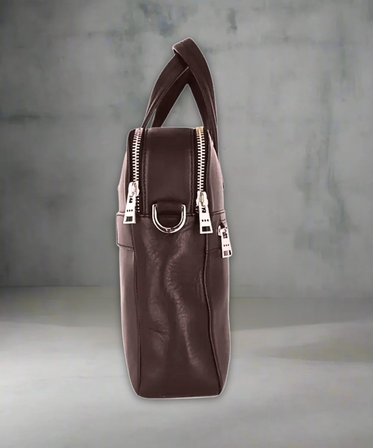 Brown Royal RepubliQ leather handbag with silver zippers on a gray background