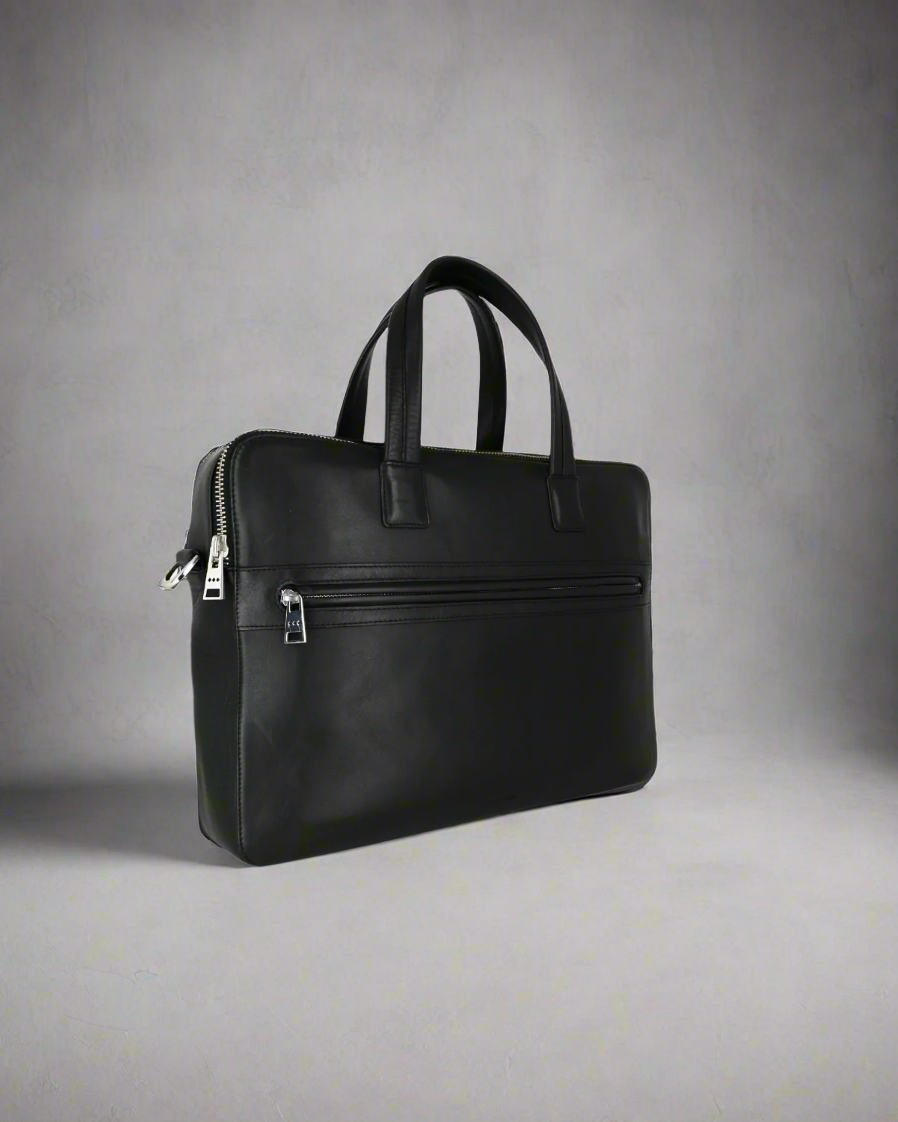 Black leather Royal RepubliQ briefcase on a gray background