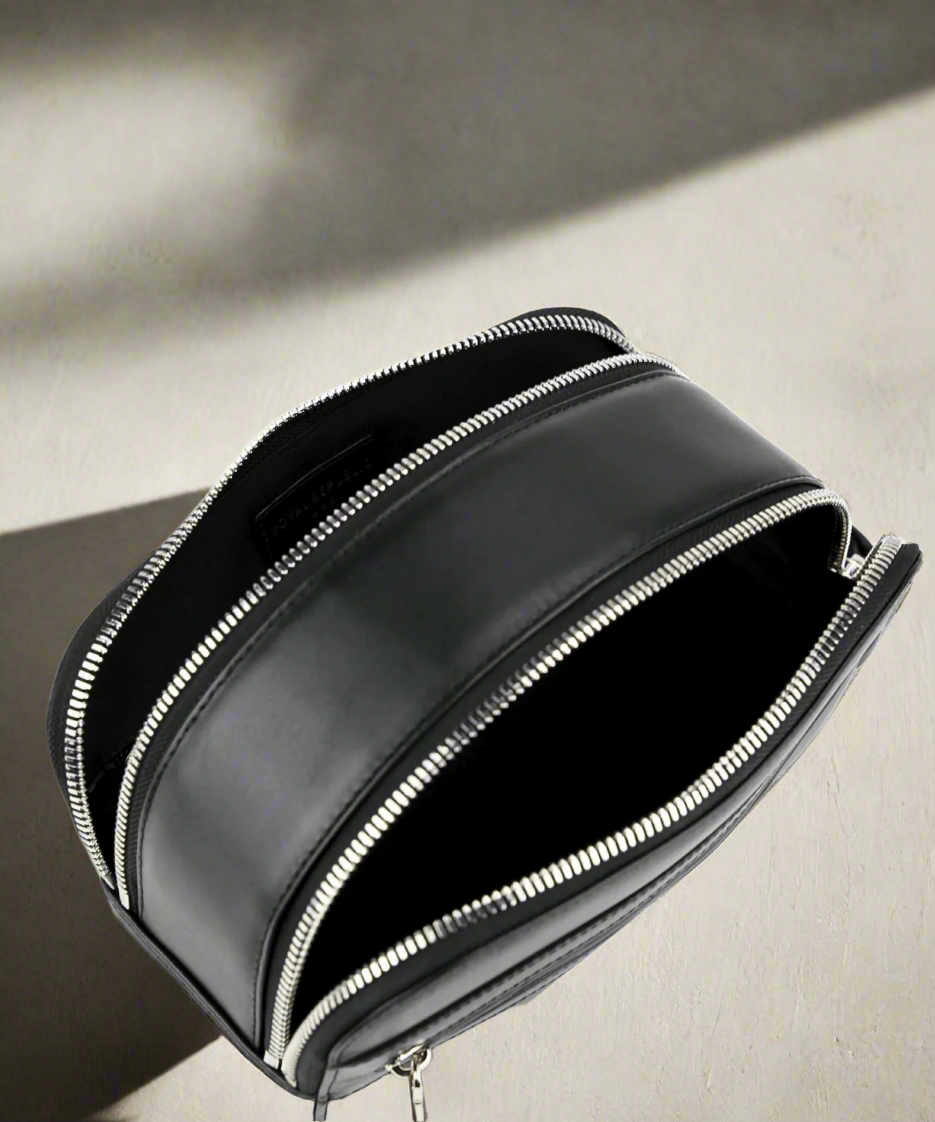 Black leather bag with silver zipper on a white background