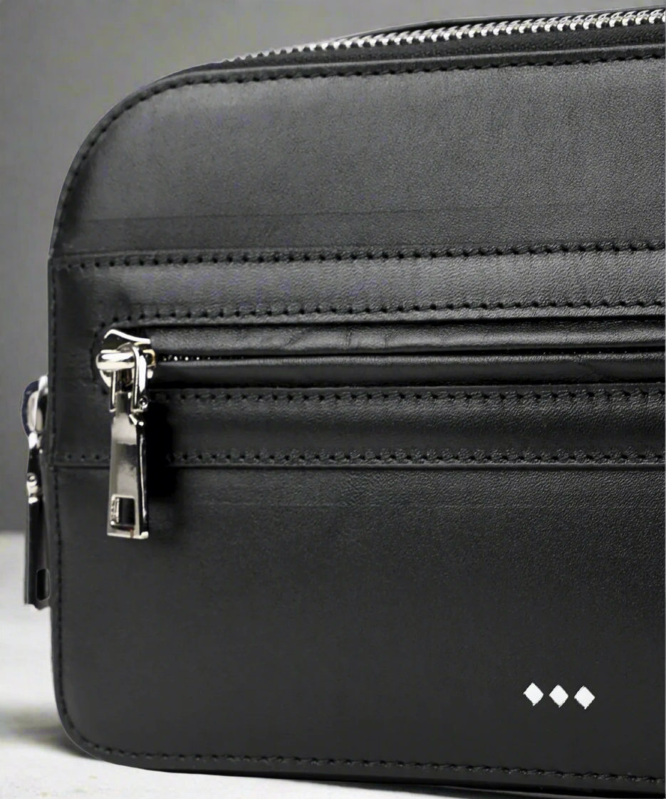 Black leather bag with zippers on a white background