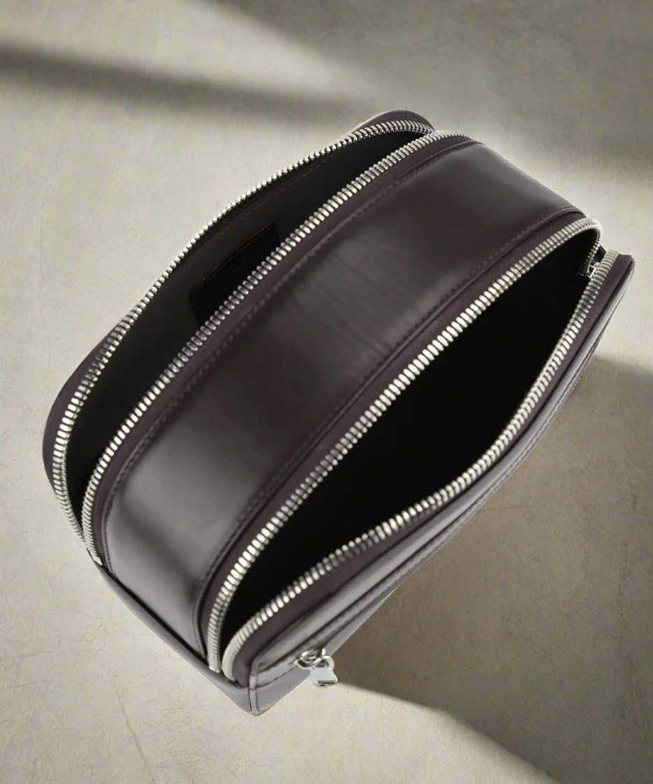 Black leather pouch with zipper on a neutral background