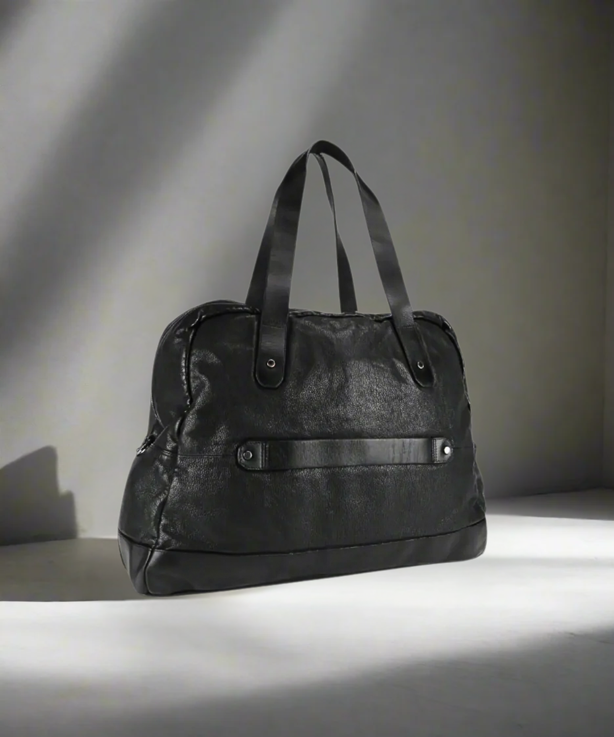 Black Royal RepubliQ washed leather weekend bag on a gray background.