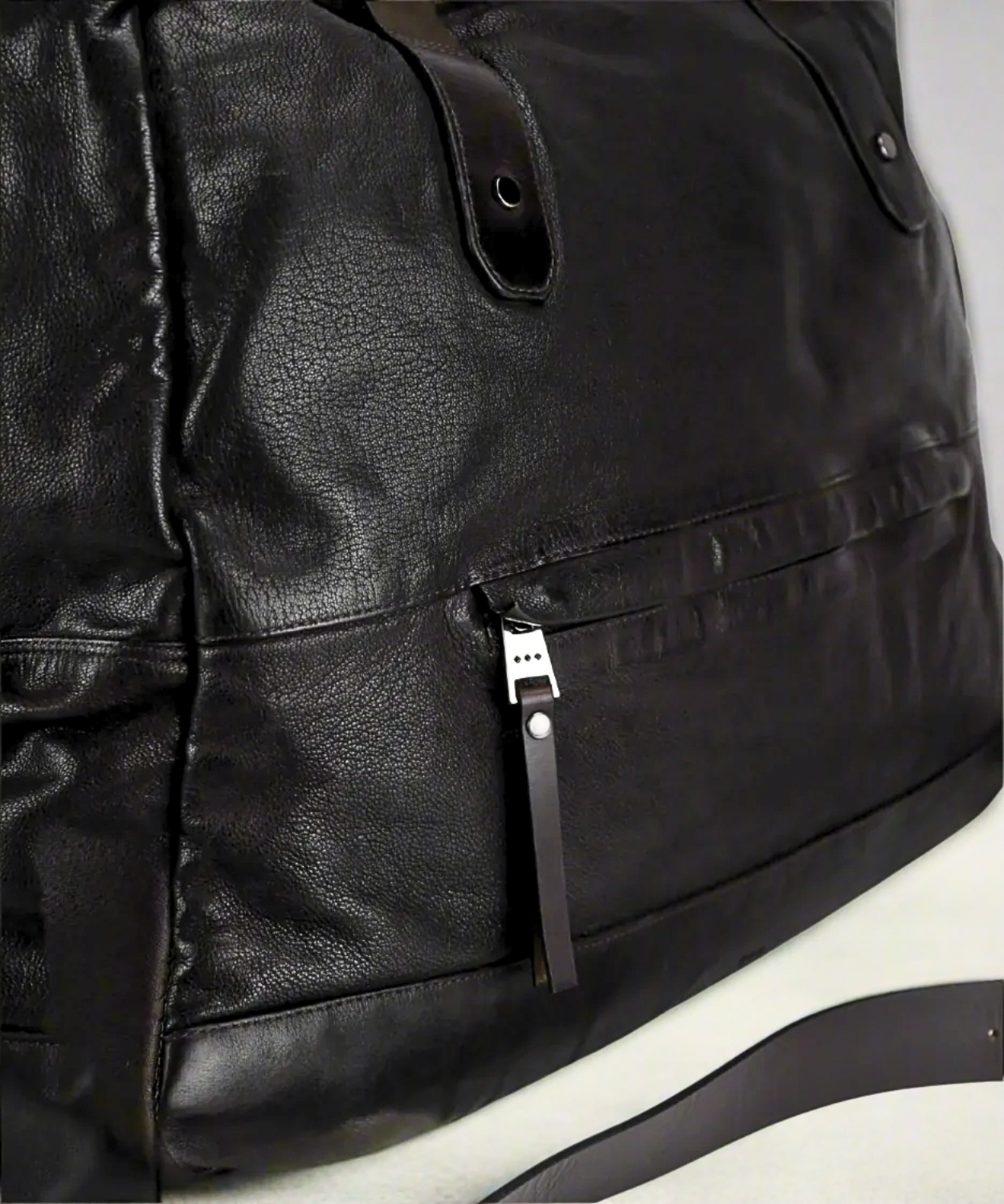 Black Royal RepubliQ washed leather weekend bag on a gray background.