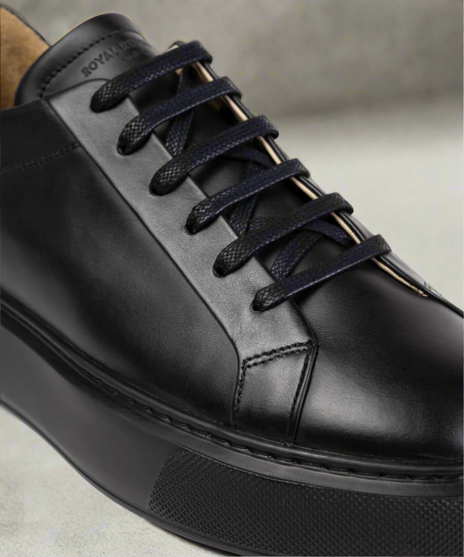 Black Royal RepubliQ leather sneaker with black laces on a neutral background