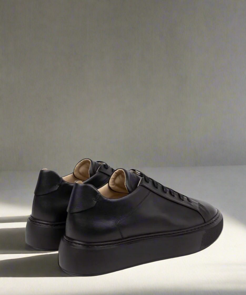 Black Royal RepubliQ leather sneakers on a gray background