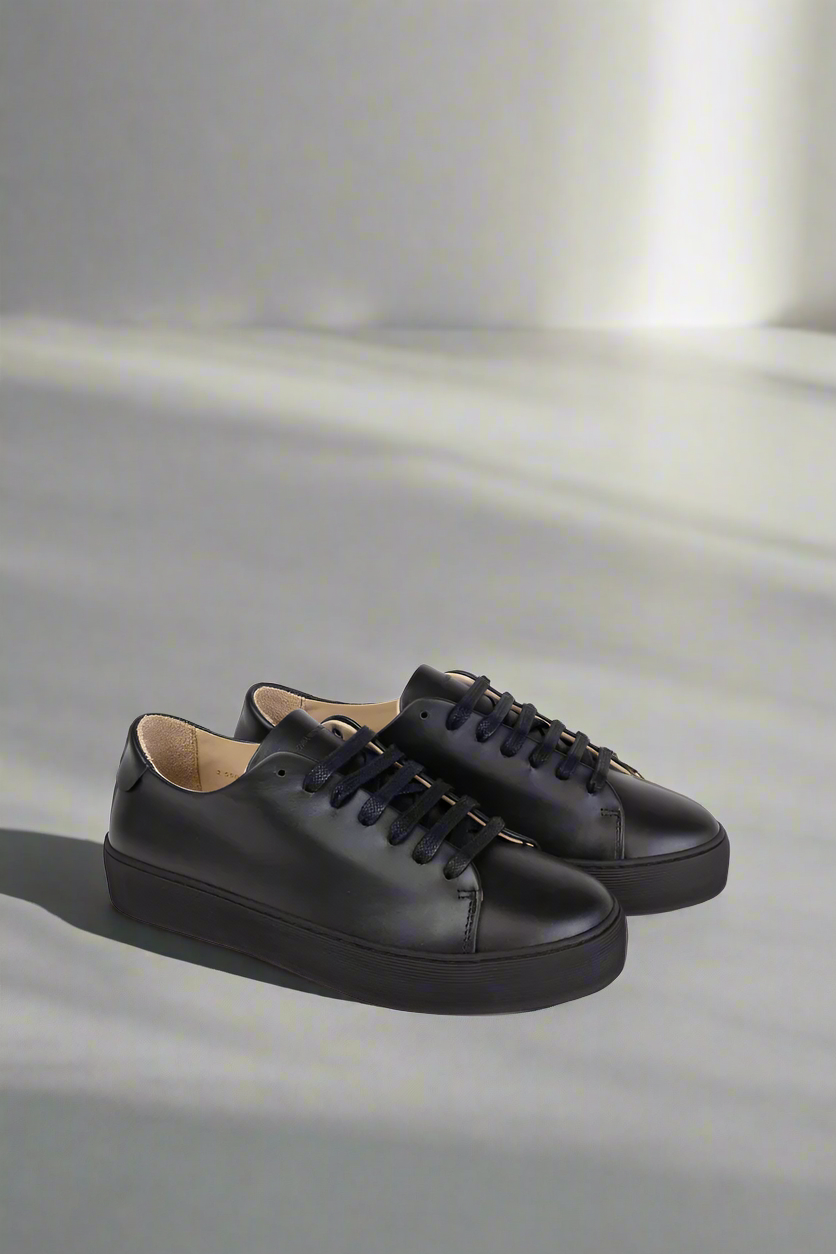 Black Royal RepubliQ minimalistic leather sneaker on a gray background