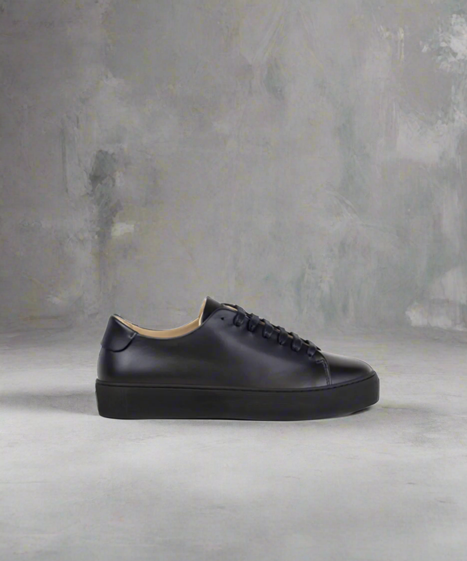Black Royal RepubliQ minimalistic leather sneaker on a gray background