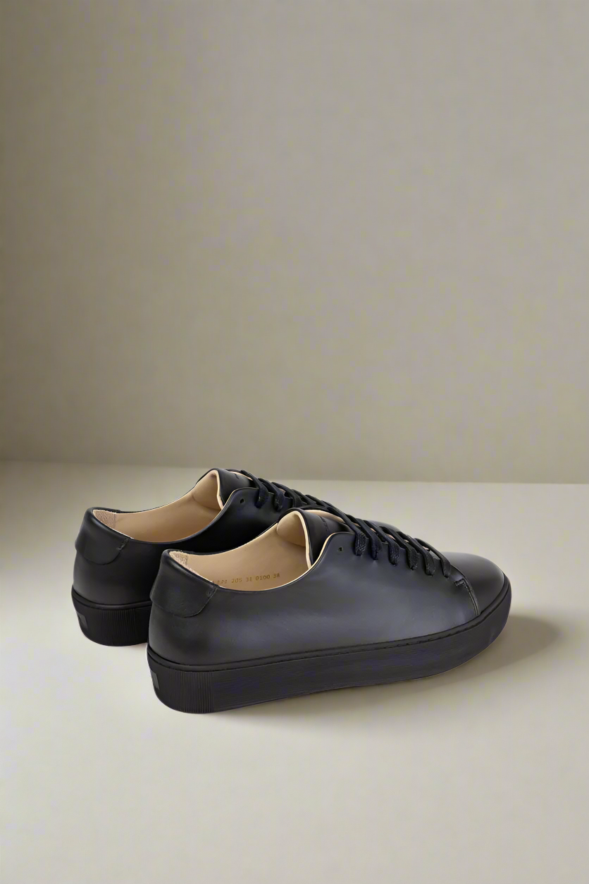 Black Royal RepubliQ minimalistic leather sneaker on a gray background