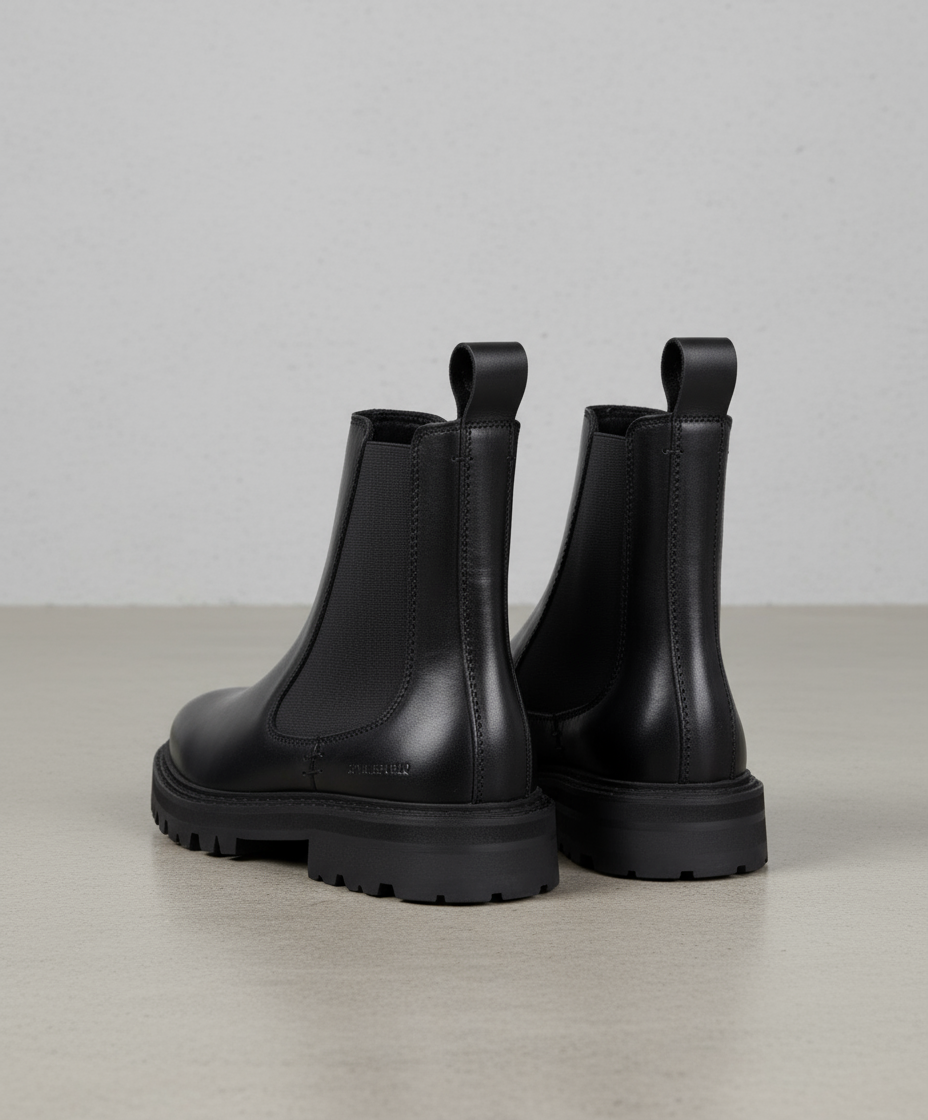Pair of black Royal RepubliQ leather Chelsea boots on a white background