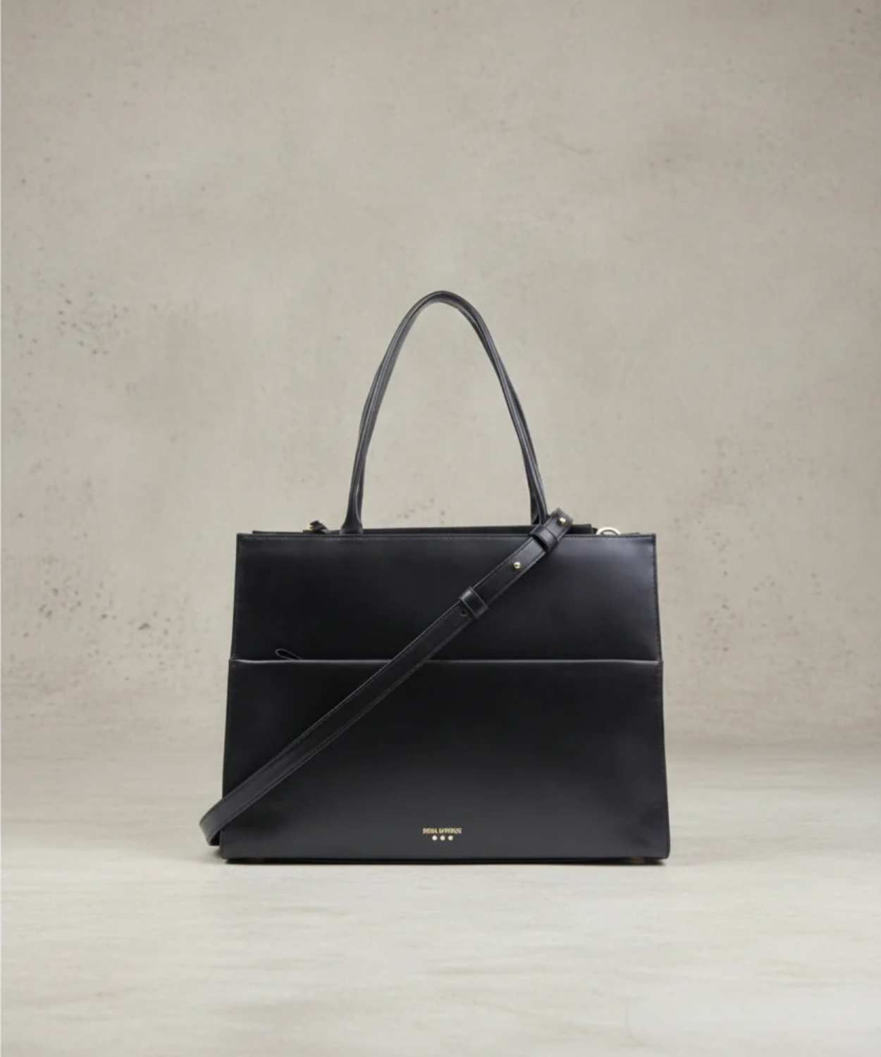 Black handbag with a shoulder strap on a light gray background