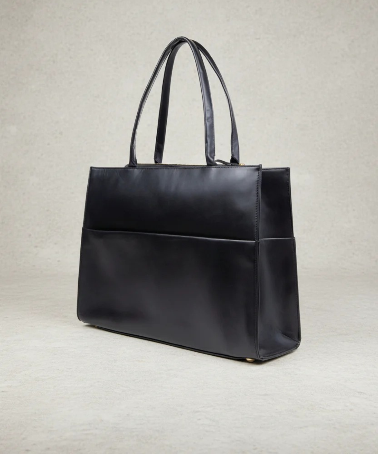 Black leather tote bag on a light gray background