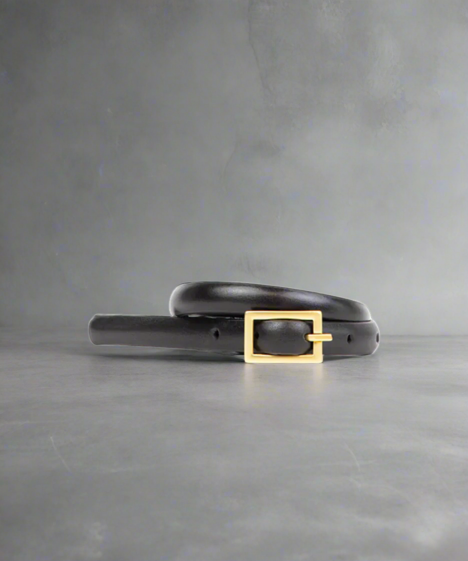 Black Royal RepubliQ Women's leather belt with a gold buckle on a gray background