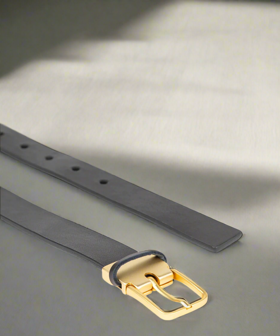 Black Royal RepubliQ leather belt for women with matt gold buckle on a textured surface