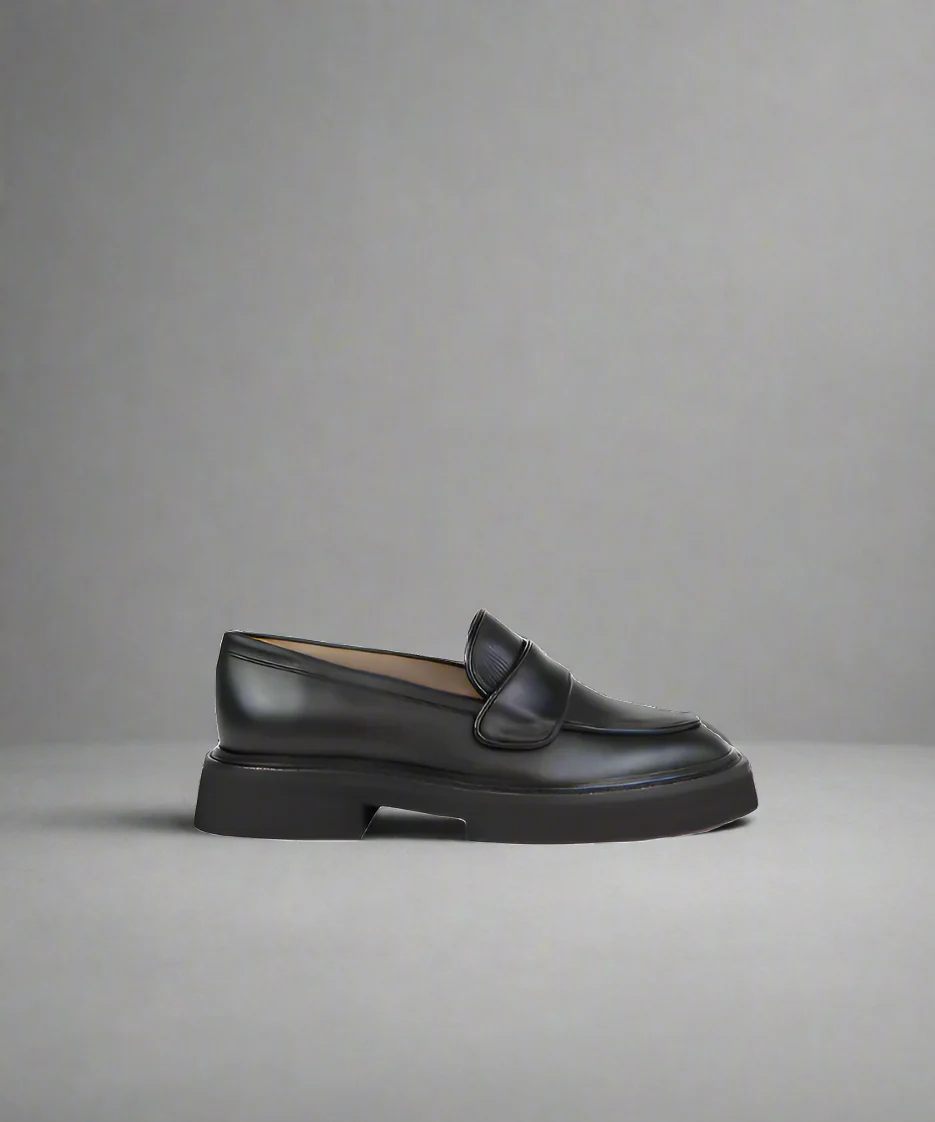 Black loafer shoe on a gray background