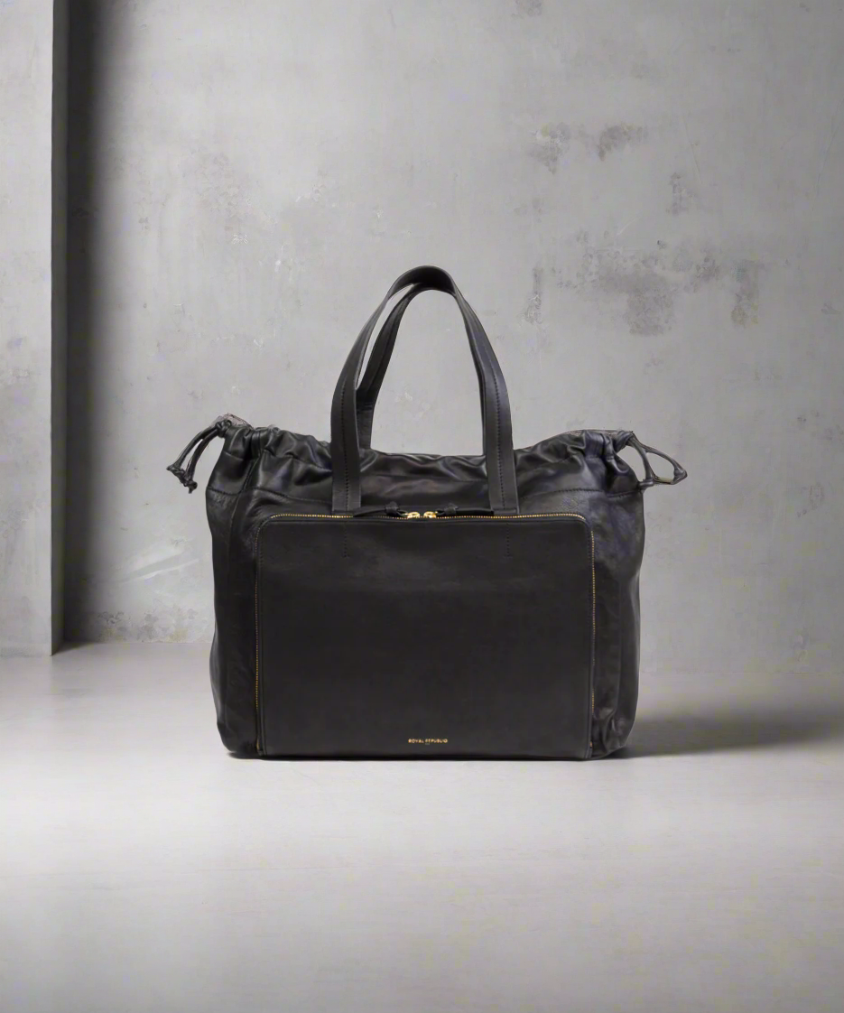 Black leather bag with drawstring on a gray background