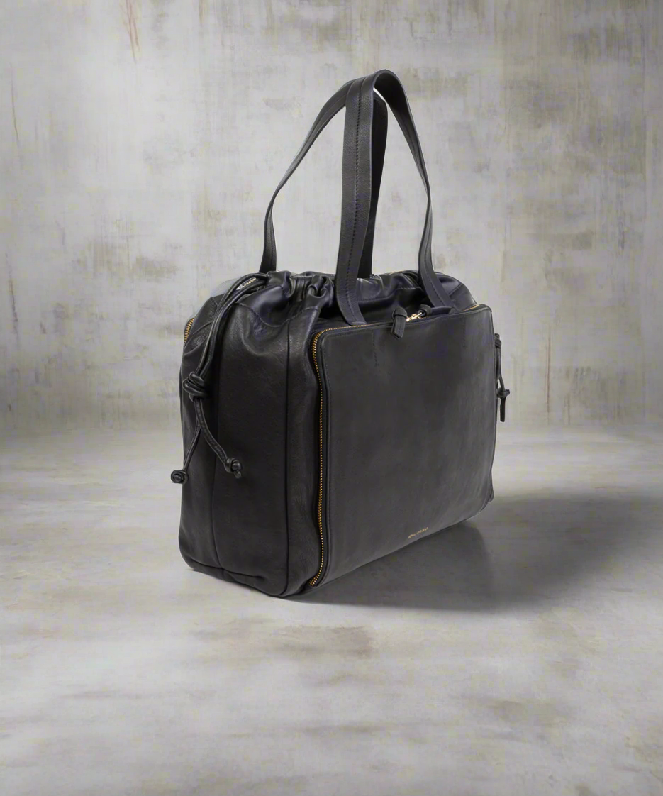 Black leather handbag on a textured gray background