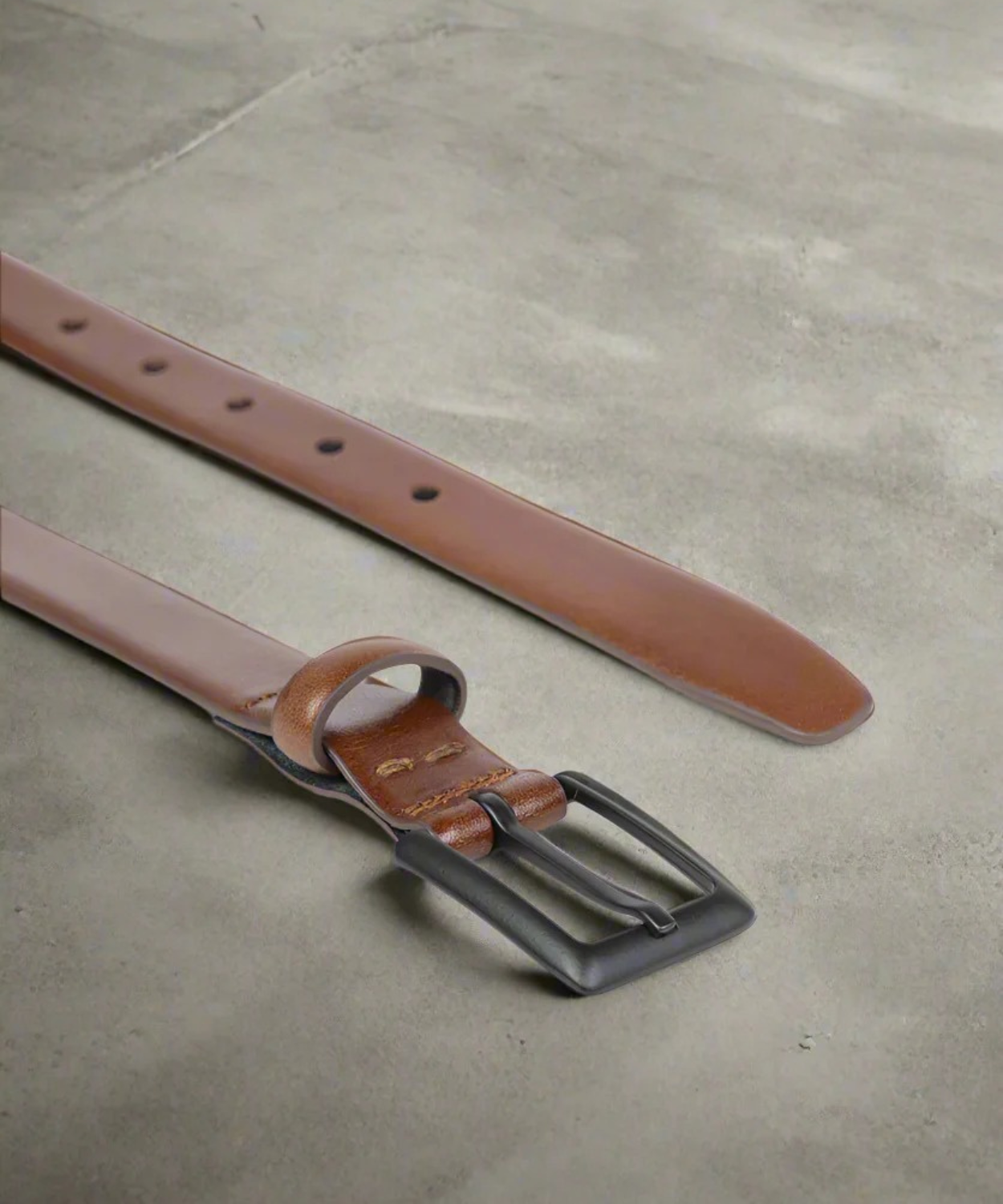 Brown 2 cm wide Royal RepubliQ leather belt with black buckle on a light gray background