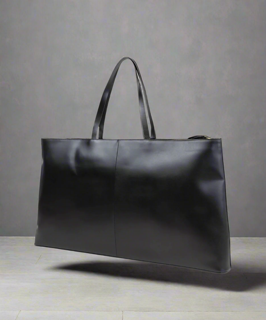 Black leather tote bag on a Gray background