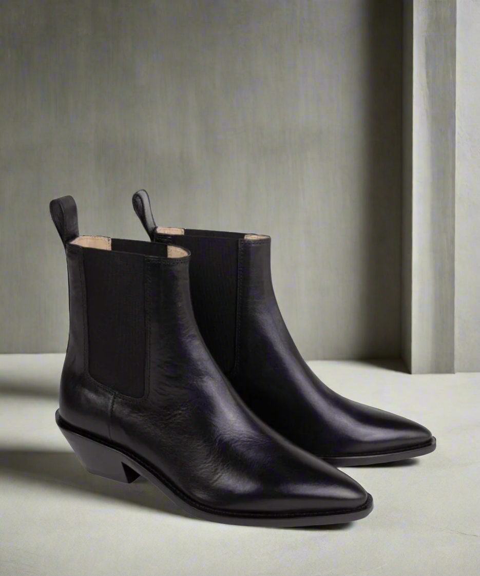 Pair of black leather Royal RepubliQ ankle boots on a neutral background R