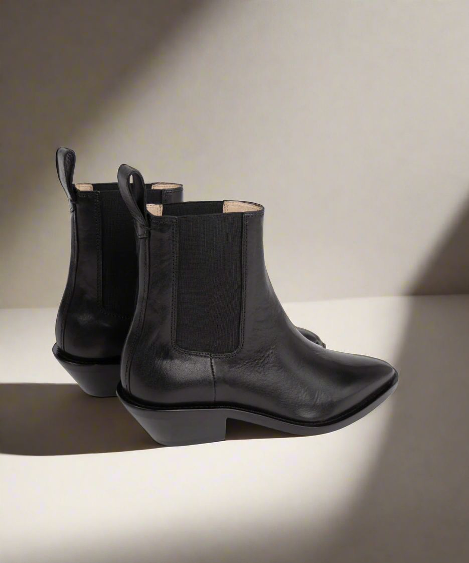 Black leather Royal RepubliQ Chelsea ankle boots on a light background