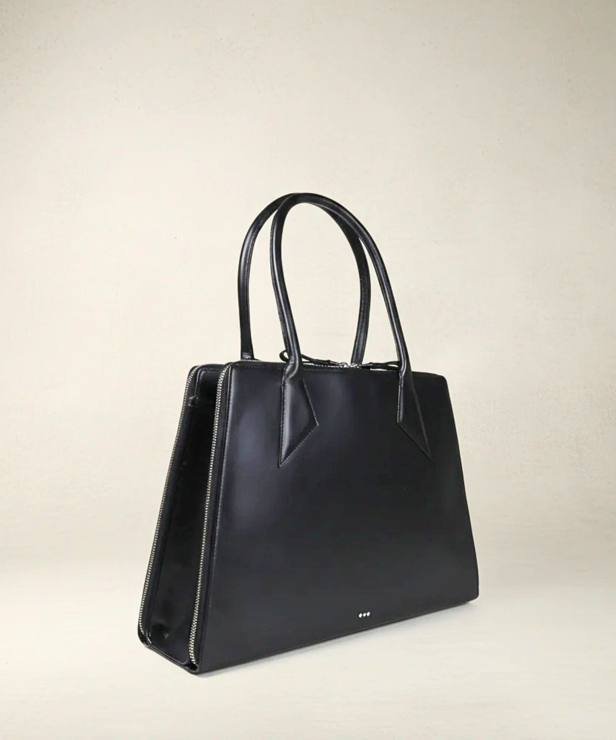 Black handbag on a beige background