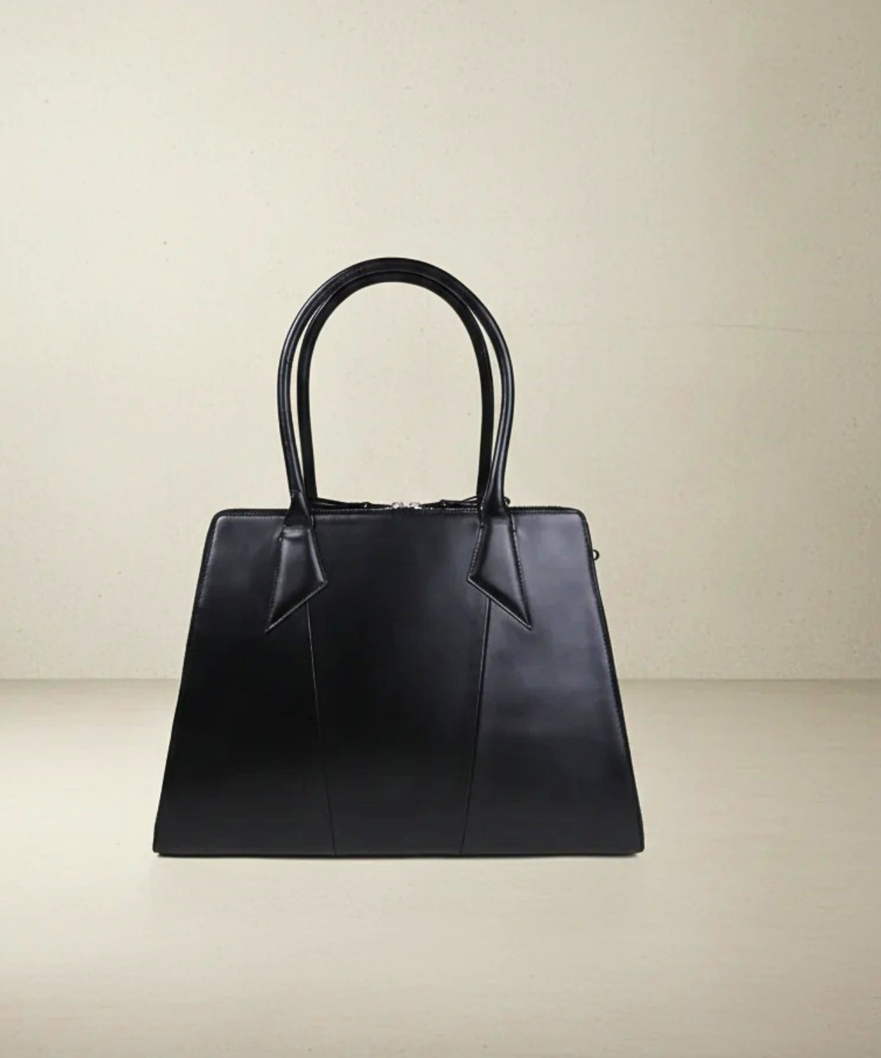 Black handbag on a beige background