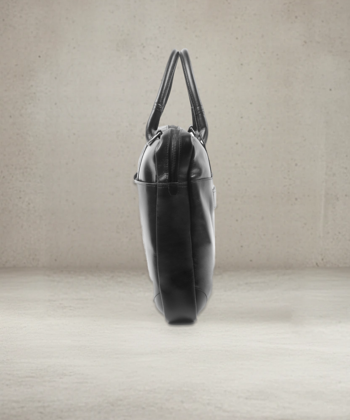 Black leather laptop bag, side view showing slim profile