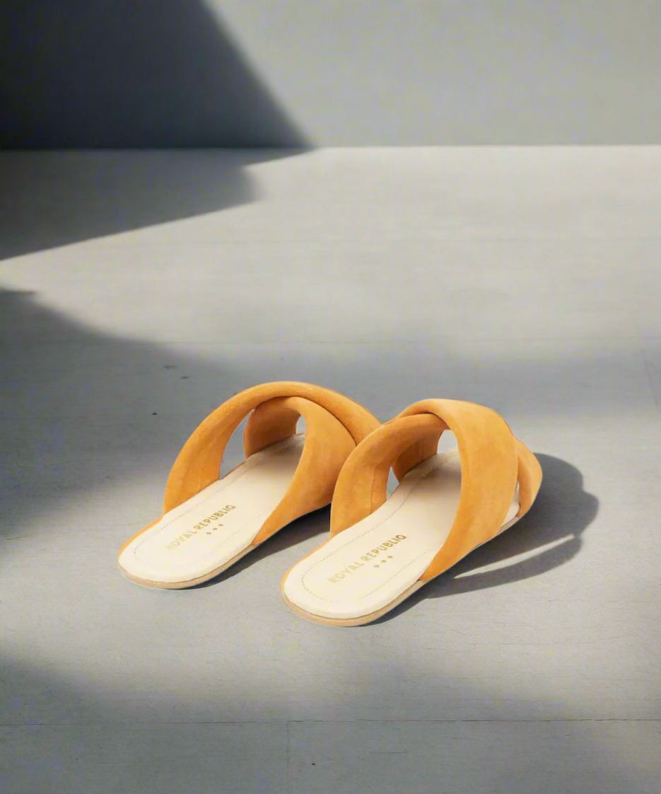 Pair of mustard yellow sandals on a gray background