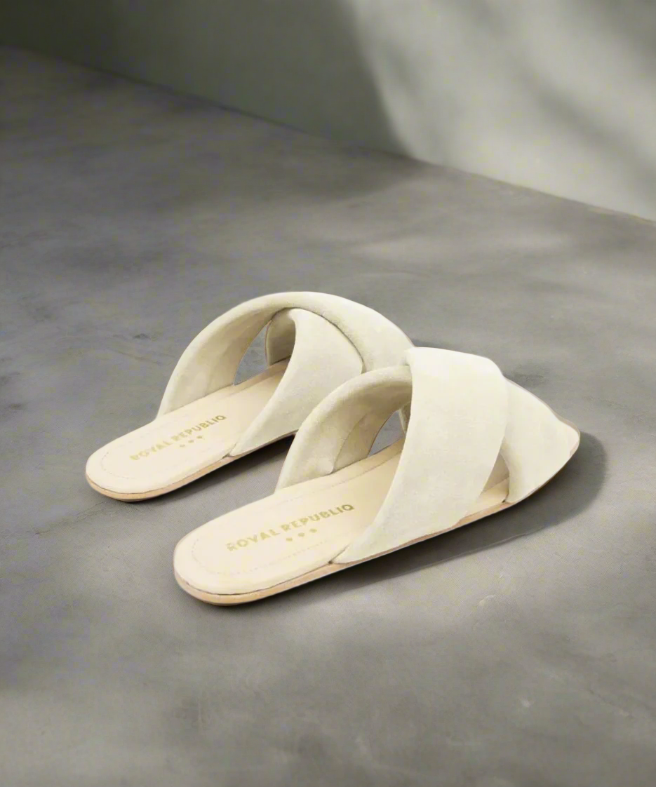 Pair of cream-colored sandals on a gray background