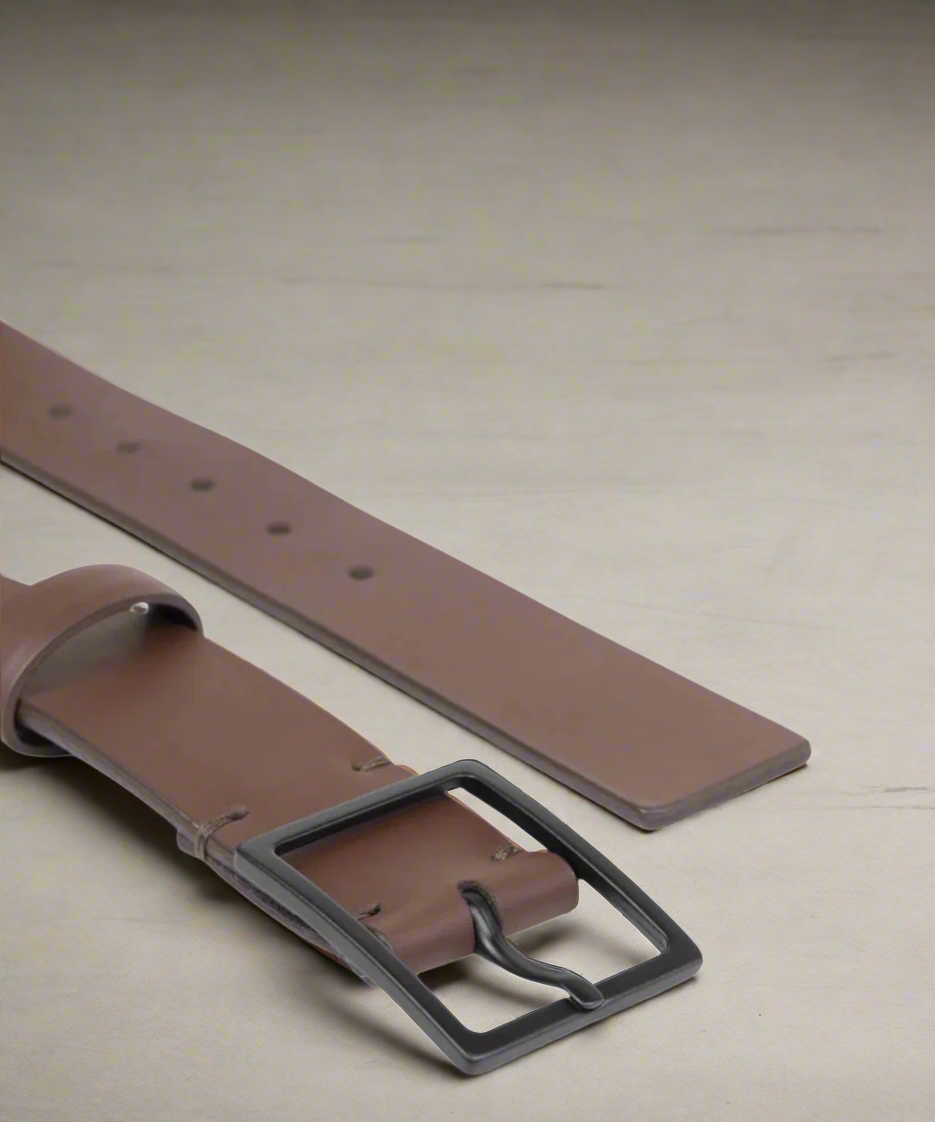 Brown leather belt with a black buckle on a gray background