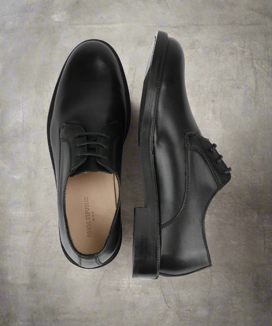 Pair of black dress shoes on a grat background
