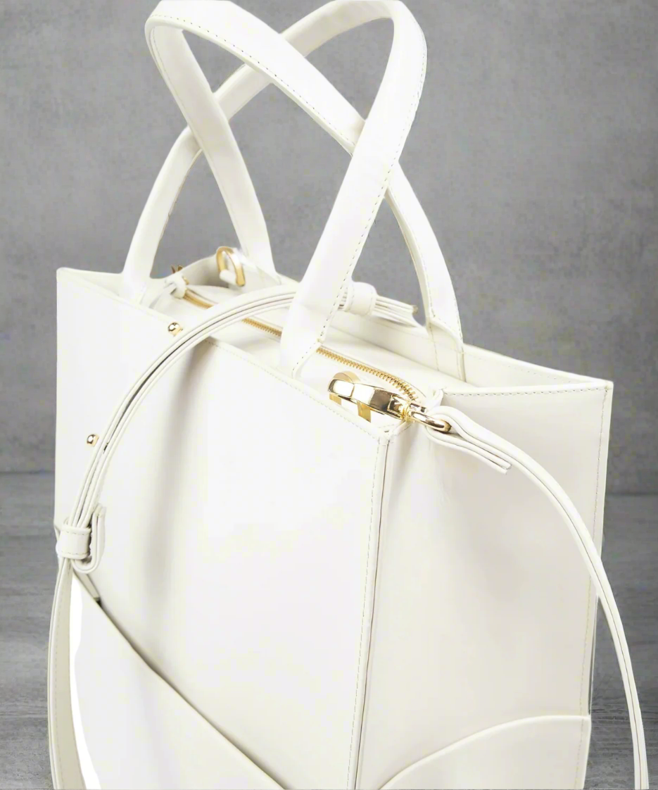 White handbag with gold accents on a GRAY background