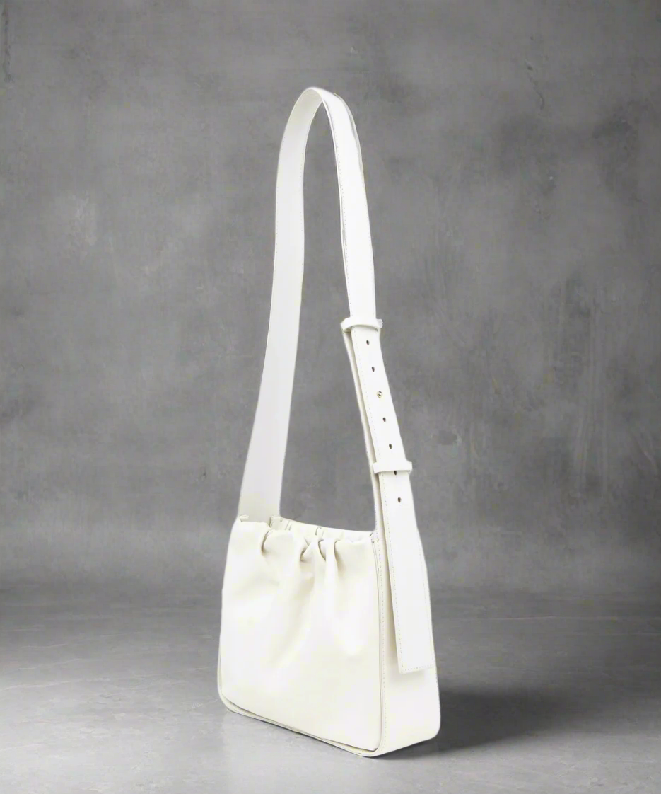 White shoulder bag on a light beige background