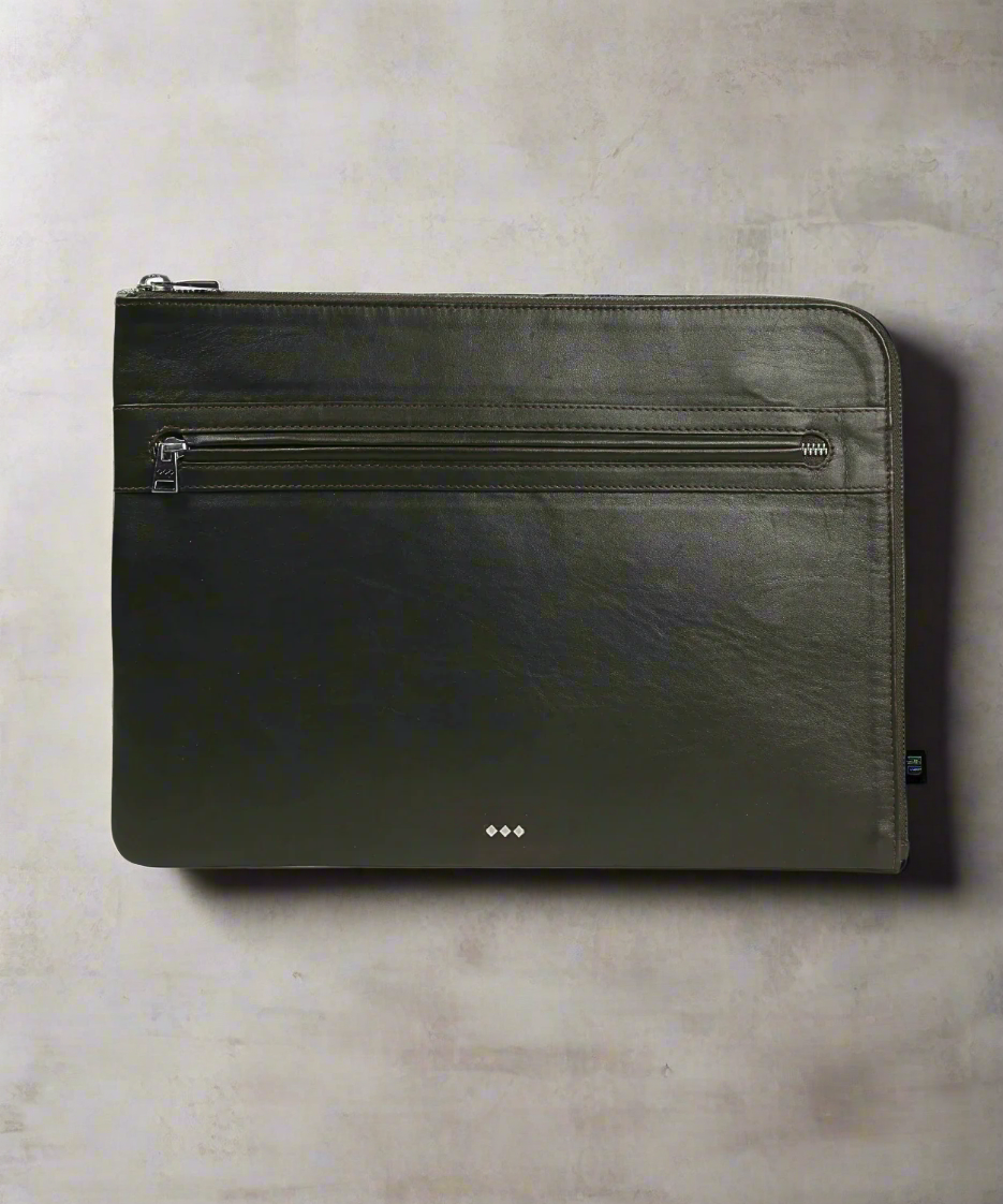 Black leather pouch with zippers on a gray background