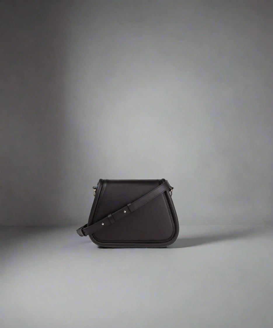 A black leather evening bag with a shoulder strap and a magnetic push-button opening.