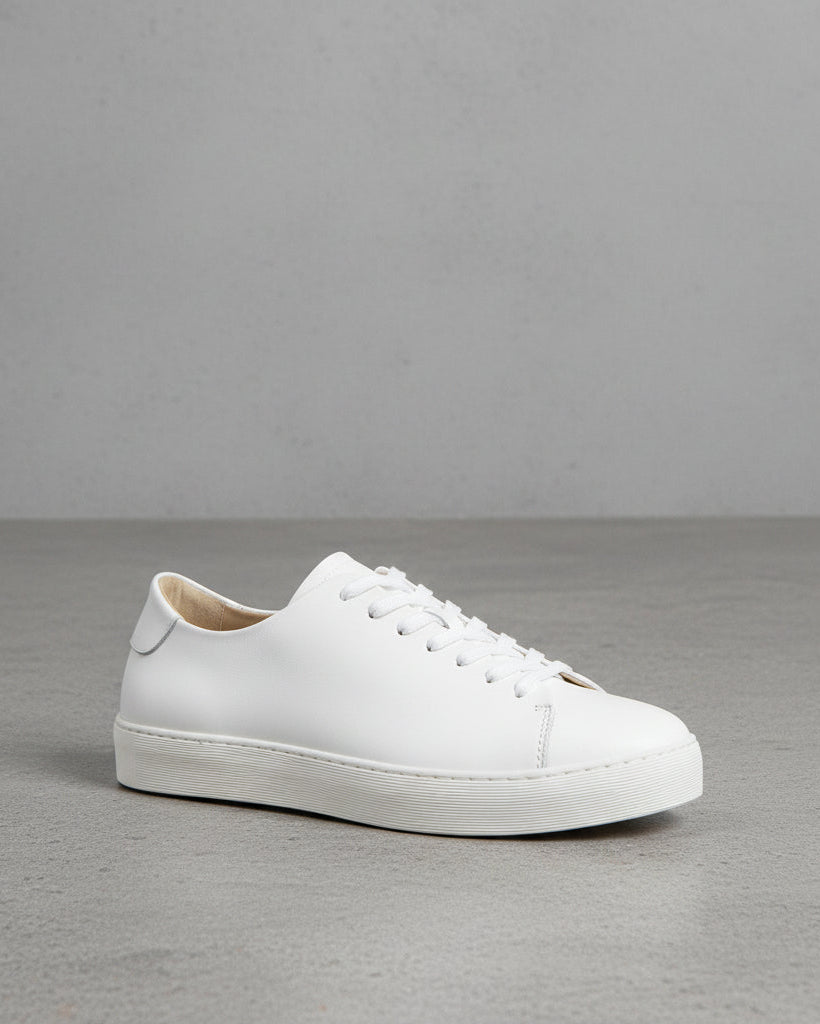 A single white Doric bound accent sneaker against a white background, showing the side profile of the shoe with visible lace eyelets and a heel counter.