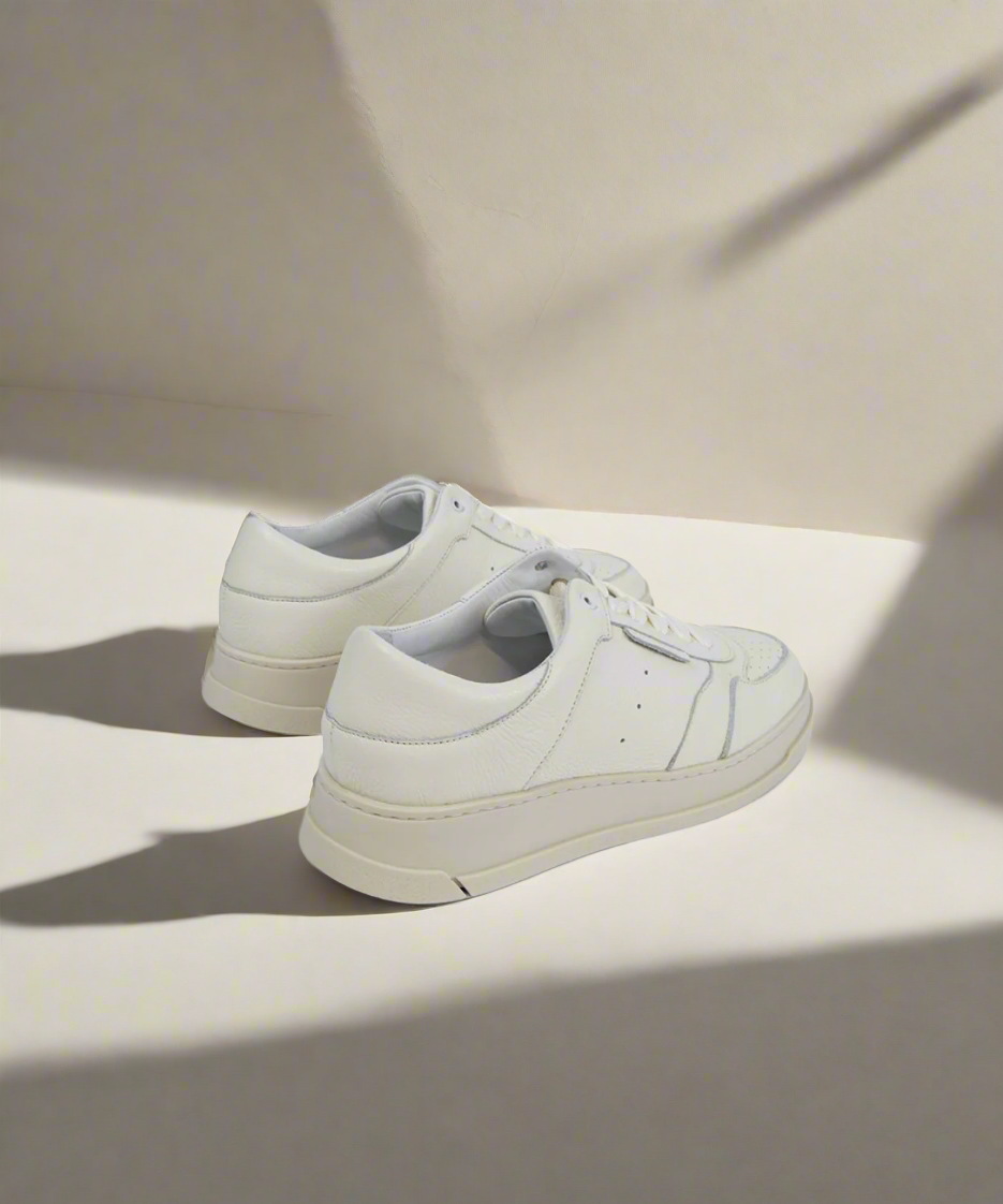White Royal RepubliQ sneakers on a light beige background