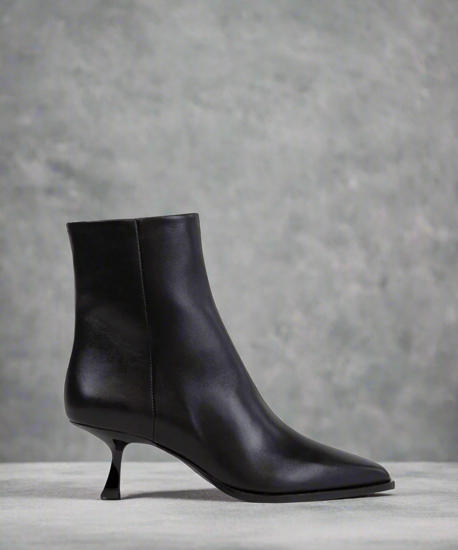 Black ankle boots on a gray background